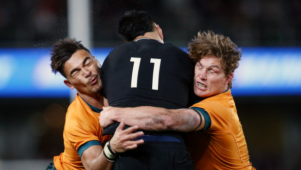Jordan Petaia (left) and (right) Michael Hooper make a tackle in Saturday’s first Bledisloe Cup match. 