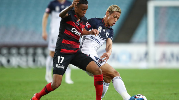 Keisuke Honda of the Victory competes with Keanu Baccus of the Wanderers.