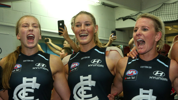 Tayla Harris (centre) and Carlton teammates belt out the club song.