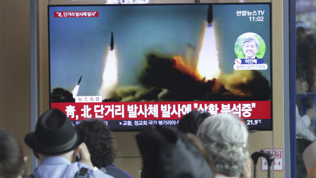 People in Seoul watch a TV showing file footage of North Korean missile launches on Saturday.