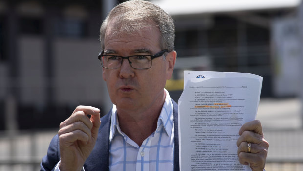 Labor leader Michael Daley holds a transcript of a testimony stating that 'all of the seats are flammable'.
