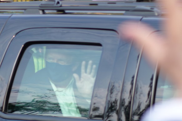 President Donald Trump, who has tested positive for coronavirus, drives past supporters gathered outside the hospital where he was being treated.