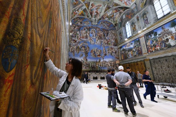 Workers prepare the Sistine Chapel for the conclave.