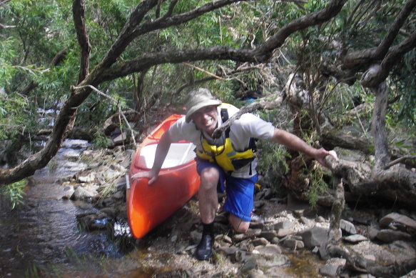 Chad McKenzie dragging his kayak through scrub along the Moorabool River near Meredith in 2016.
