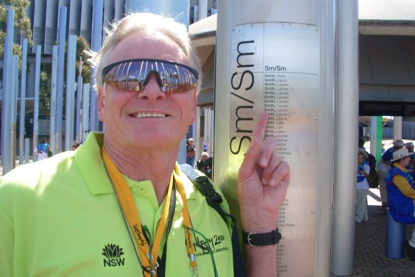 Laurie Smith poses next to his name on the honour roll outside Stadium Australia.