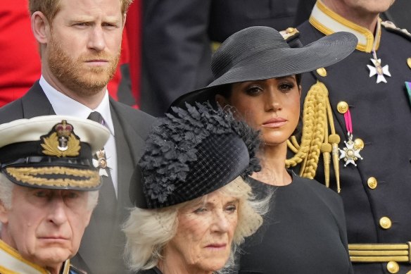 King Charles III, Camilla, the Queen Consort, Prince Harry and Meghan, Duchess of Sussex watch as the coffin of Queen Elizabeth II is placed into the hearse following the state funeral service in Westminster Abbey last year.