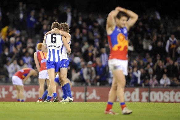 Dejected Lions players look on as the Roos celebrate the win.