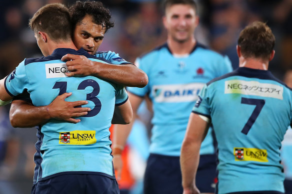 Relieved Waratahs players celebrate their first win of the season on Friday night.