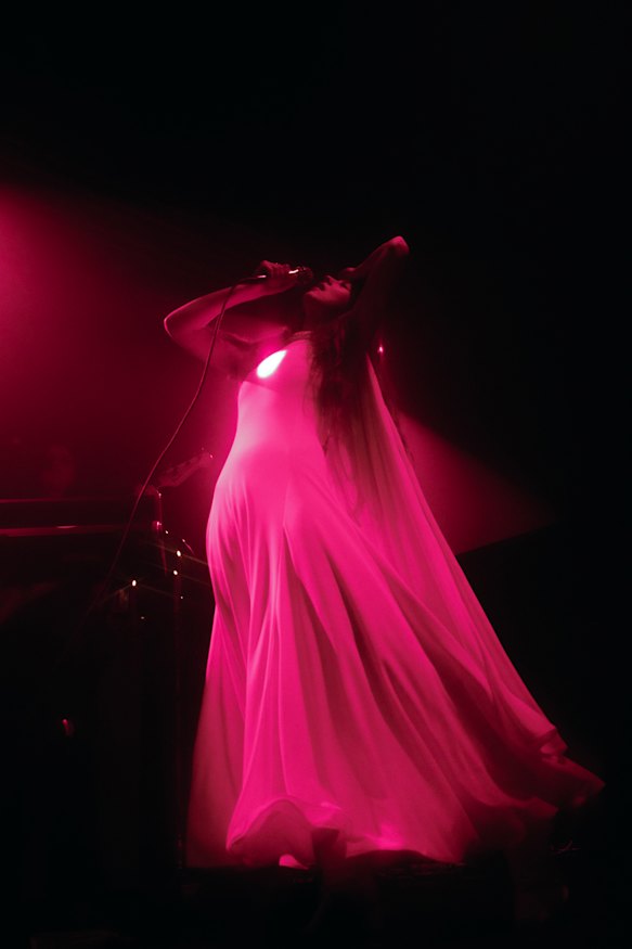 Weyes Blood - with her glowing heart - on stage.