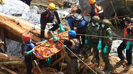 Rescuers evacuate the body of a flood victim in West Sumatra.