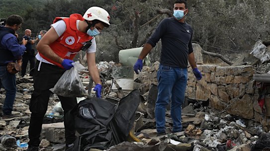 Villagers and the Red Cross sift through the rubble of a house flattened by an Israeli air strike in Aitou, Lebanon.