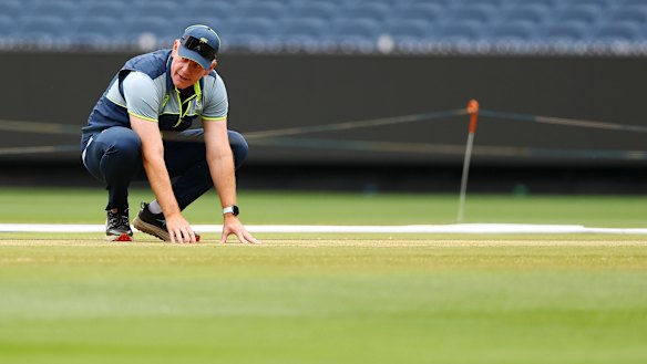 Australia coach Andrew McDonald inspects the MCG pitch on Christmas Eve.