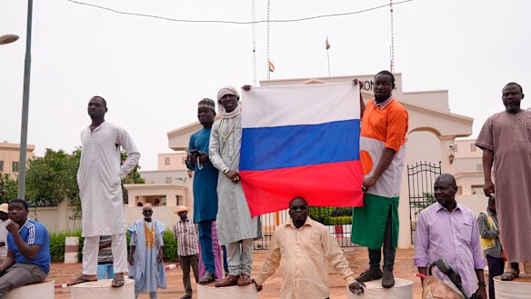 Supporters of mutinous soldiers hold a Russian flag as they protest in Niamey, Niger.