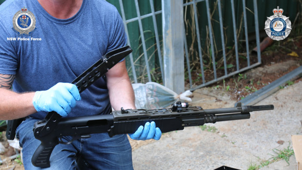An officer with one of the seized firearms.