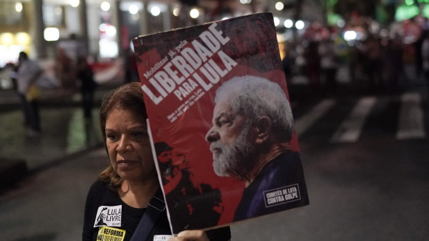 A woman holds a banner with an image of Brazil's former President Luis Inacio Lula da Silva with the Portuguese message: "Freedom to Lula," during a protest against government-proposed pension reforms.