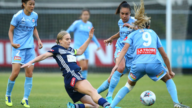 Under pressure: Victory skipper Natasha Dowie clears as City players close in.