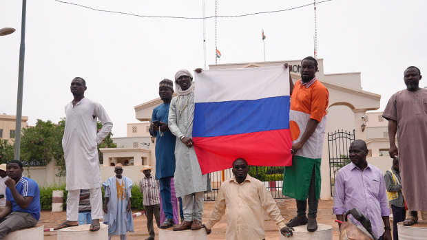Supporters of mutinous soldiers hold a Russian flag as they protest in Niamey, Niger.