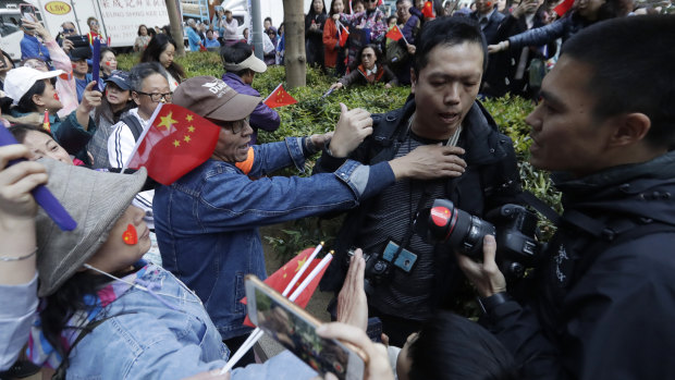 A pro-Beijing supporter yells and pushes a photographer during a rally in Hong Kong on December 7.