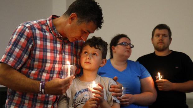 Durant Kreider embraces his son Gavin, 9, during a vigil for the victims of the shooting at St John's Baptist Church, in Virginia Beach.