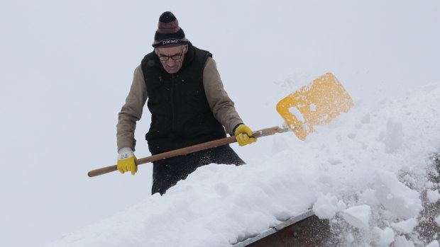 A man shovels snow from the roof of his house in a remote village near Kladanj, 80 kms north of Sarajevo, Bosnia, on Friday.