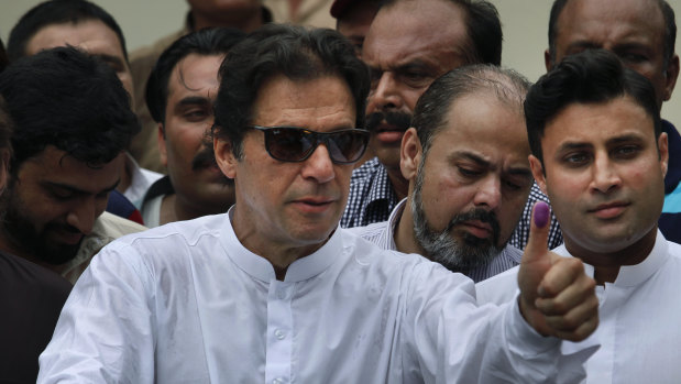 Imran Khan shows his marked thumb after casting his vote.