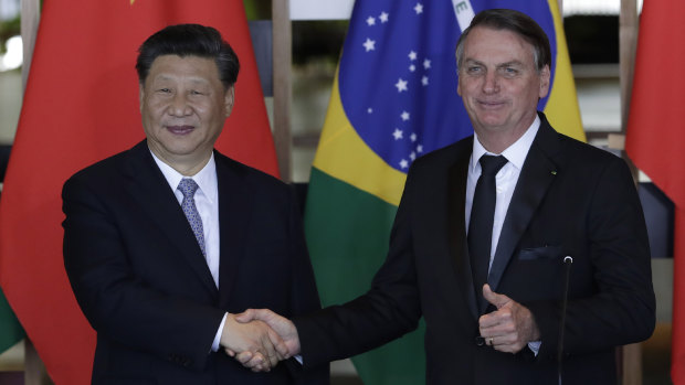 Chinese President Xi Jinping, left, and Brazilian President Jair Bolsonaro shake hands at a bilateral meeting on the sidelines of the 11th  BRICS Summit in Brasília, Brazil.