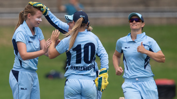 Lauren Cheatle is congratulated by the Breakers after taking a wicket in the domestic one-day final.