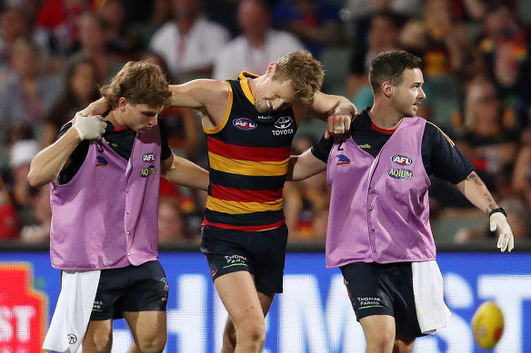 Rory Sloane winces in pain as he leaves the field injured.