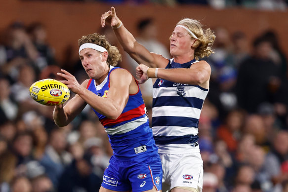 Aaron Naughton of the Bulldogs and Sam De Koning of the Cats compete for the ball.