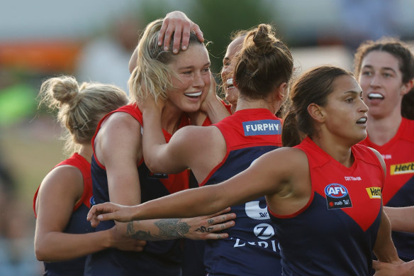 Tayla Harris is surrounded by her Demons teammates after scoring.