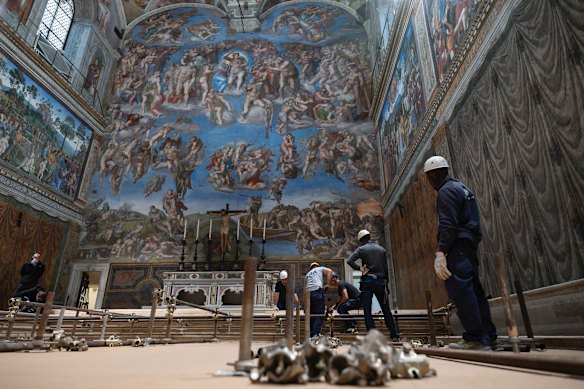 Workers lay a temporary floor to level the space beneath Michelangelo’s famous frescoes.