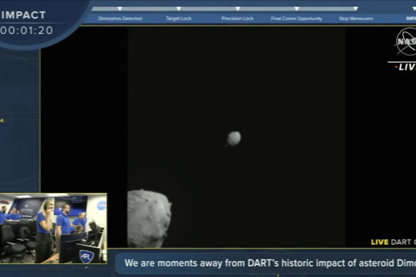 An image from the NASA livestream shows the DART spacecraft close in on the white speck of asteroid Dimorphos while passing the larger asteroid Didymos. 