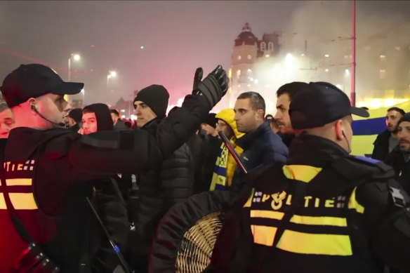 Police escort Maccabi Tel Aviv supporters to the metro station before the Ajax game.