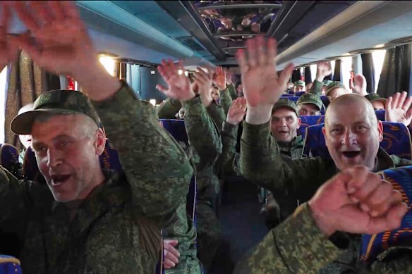 Released Russian servicemen react as their bus arrives at an airport outside Moscow.