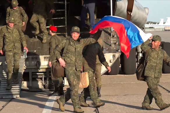 Russian servicemen leave a plane after returning from captivity in Ukraine.