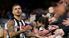 Bobby Hill of the Magpies high-fives fans.