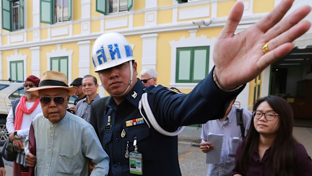 Thai social critic Sulak Sivaraksa is escorted outside a military court earlier this year, when the latest lese-majeste charges against him were dropped.