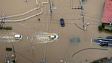 Cars make their way through a flooded road after heavy rain in Oamishirasato, Chiba.