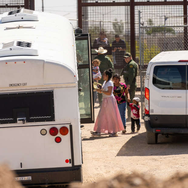 On the day Title 42 is set to expire, migrants are directed onto US government buses after crossing through a section of the border wall in El Paso, Texas.