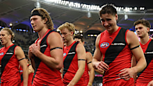 Essendon players leave the field in Perth.