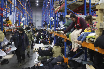 Migrants settle in a logistics center at the checkpoint “Kuznitsa” at the Belarus-Poland border near Grodno, Belarus, on Friday.