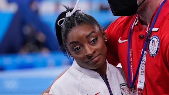 Coach Laurent Landi embraces Simone Biles after she quit the Team final at the Olympics.
