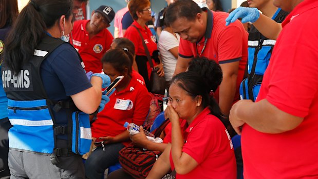 Medics attend to supporters of the former first lady outside a sports arena that hosted the birthday celebration.