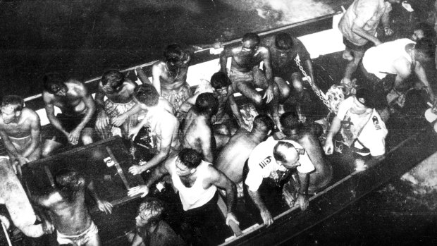 Survivors picked up by naval rescue craft prepare to board the aircraft carrier. 