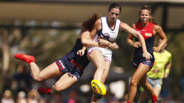 Boot to ball: Fremantle's Laura Pugh stays steady despite being caught by a flying tackle.