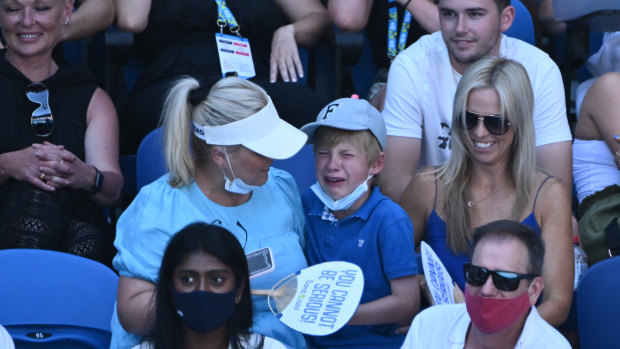 A boy in the crowd reacts after being struck by a ball hit by Nick Kyrgios.