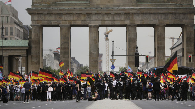AfD supporters wave flags in front of the Brandenburg Gate in Berlin, Germany last May.