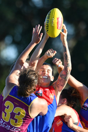 Tegan Cunningham (centre) of the Demons is spoiled while going for a mark.