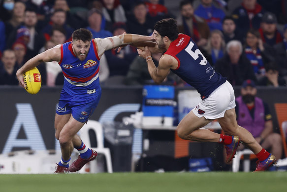Marcus Bontempelli attempts to evade a tackle by Christian Petracca.