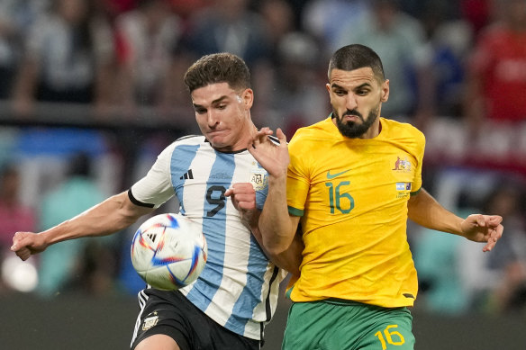 Argentina’s Julian Alvarez, left, and Australia’s Aziz Behich vie for the ball.